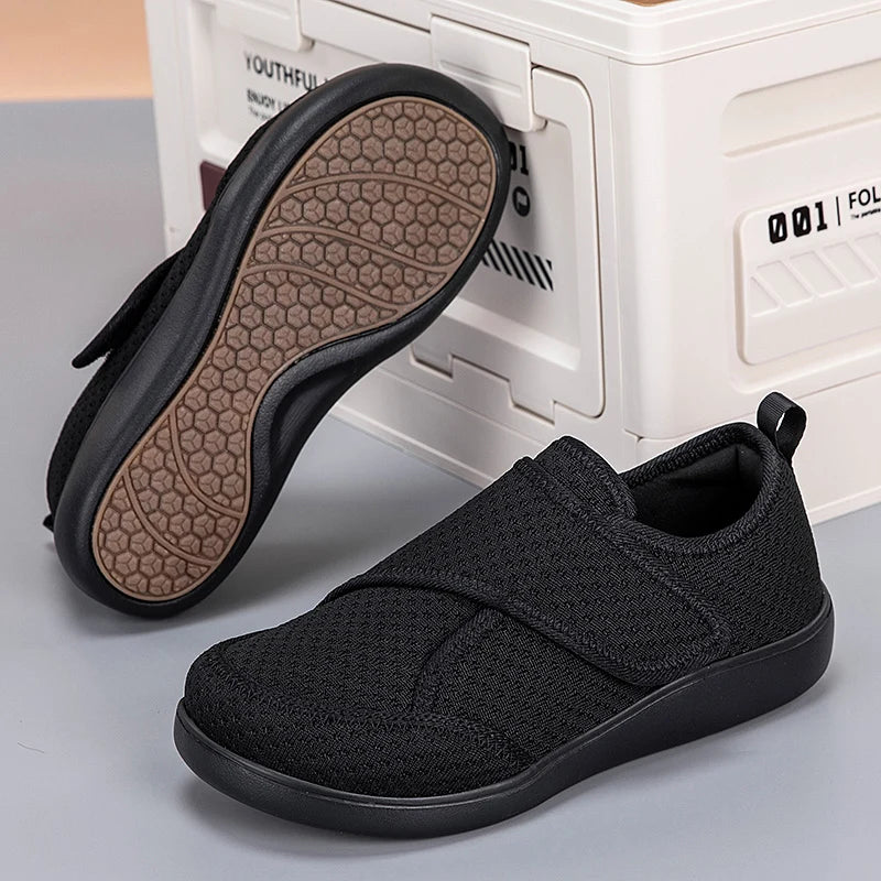 Schwarze Klettschuhe auf grauem Untergrund, ein Schuh umgedreht mit braunem Wabenprofil an der Sohle 6