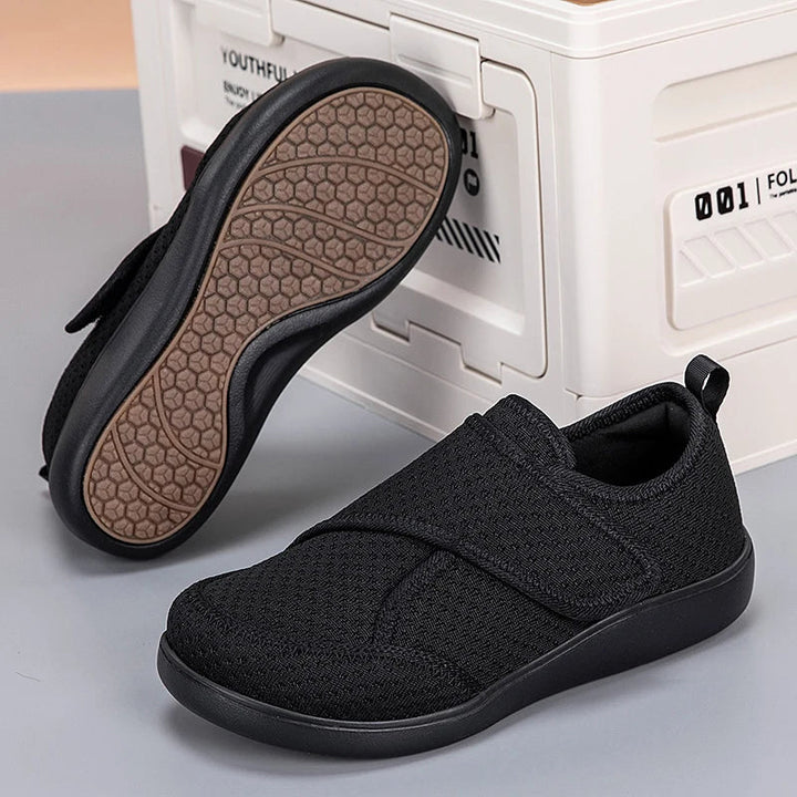 Schwarze Klettschuhe auf grauem Untergrund, ein Schuh umgedreht mit braunem Wabenprofil an der Sohle 6