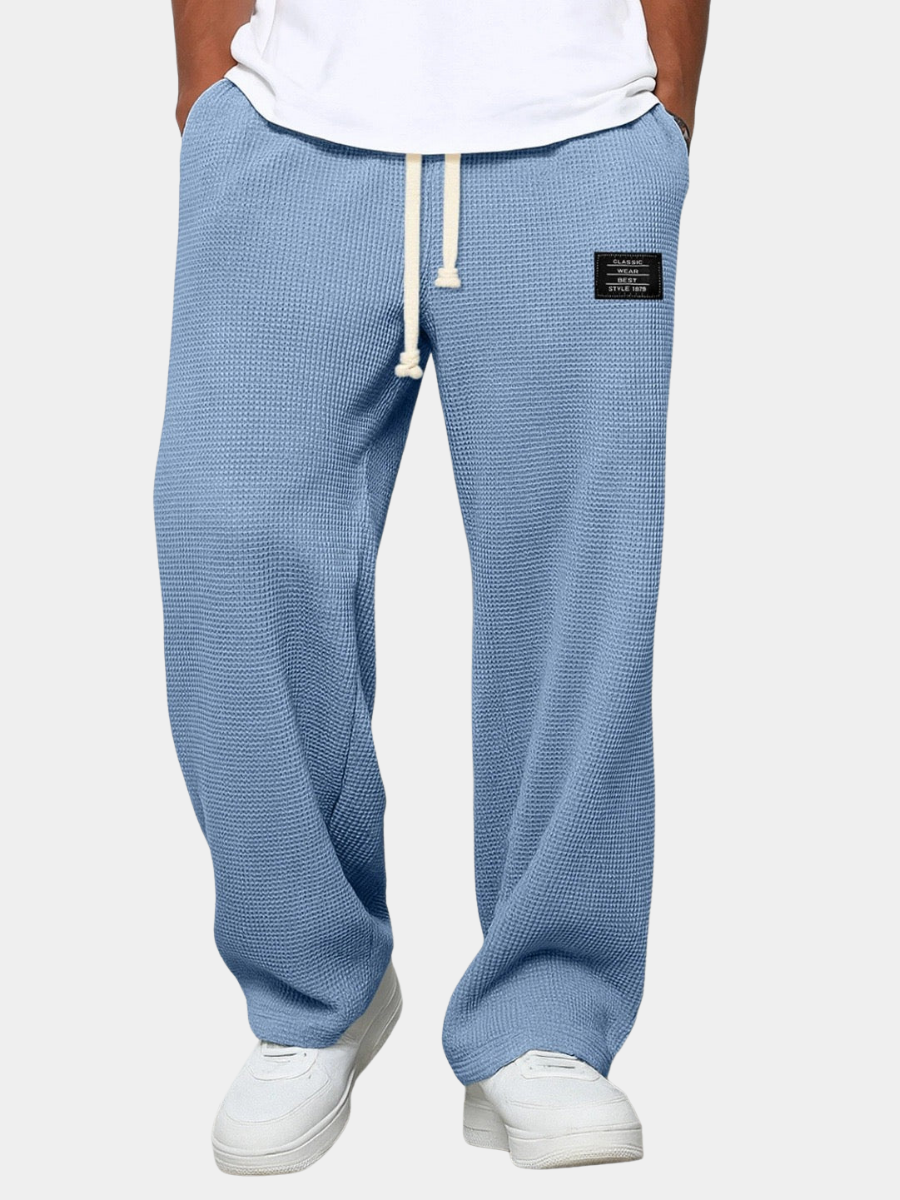 Die Hose in Hellblau, vor neutralem Hintergrund getragen, mit Kordelzug am Bund und weitem, geradem Bein. 4