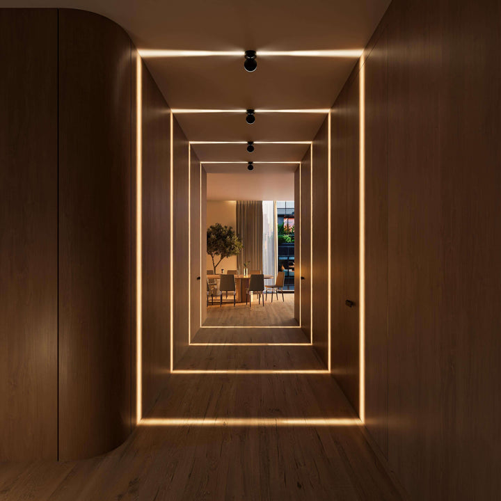 Abendlicher Holzflur mit schwarzen Leuchten, die konzentrische rechteckige Lichtlinien an Wände, Decke und Boden werfen. 18