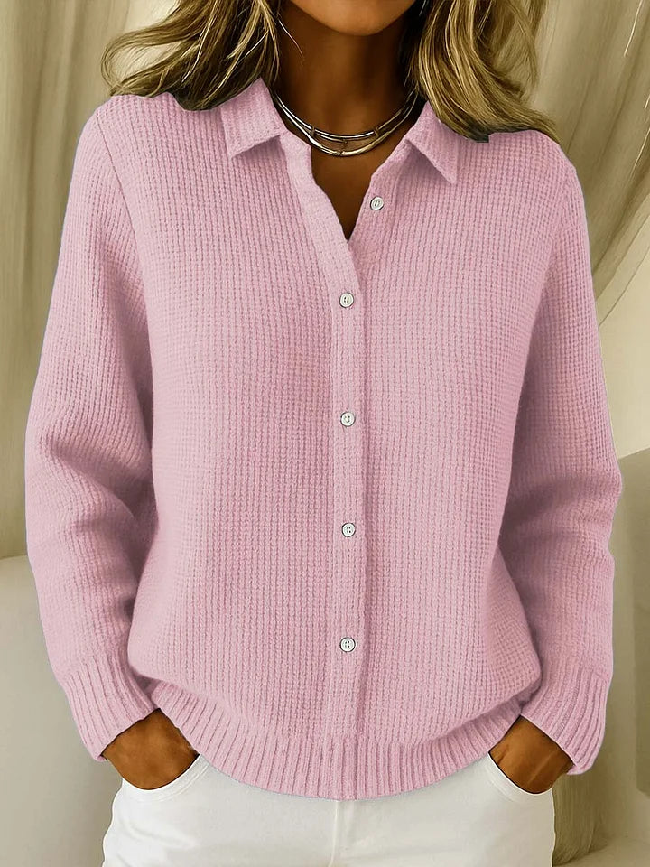 Dasselbe Modell in Rosa, getragen mit weißer Hose, mit Kragen, durchgehender Knopfleiste und gerippten Bündchen an Ärmeln und Saum. 2