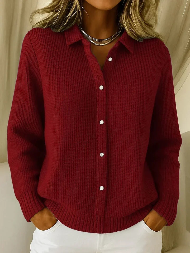 Der Strickpullover in dunklem Weinrot am Model, Frontansicht mit Kragen, weißen Knöpfen und feiner Waffelstruktur. 3
