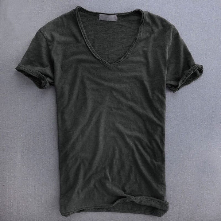 Dunkelgraues T-Shirt mit V-Ausschnitt und rohen Kanten am Halsausschnitt, flach auf grauer Fläche ausgelegt. 4