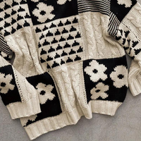 Schwarz-weißer Strickpullover mit geometrischem und Blumenmuster, grob gestrickt, Unisex-Design.