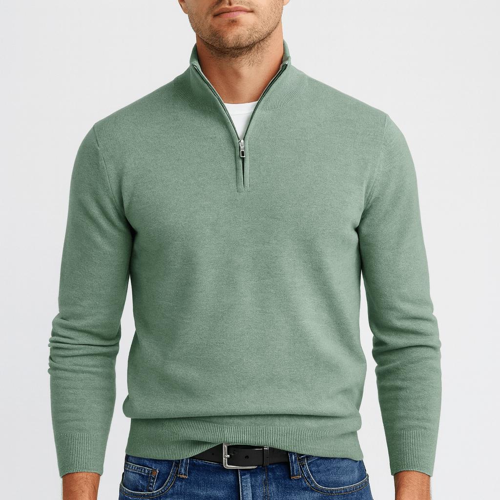 Mann trägt den Pullover in Salbeigrün mit Stehkragen und Reißverschluss, ergänzt durch Jeans und schwarzen Ledergürtel. 5
