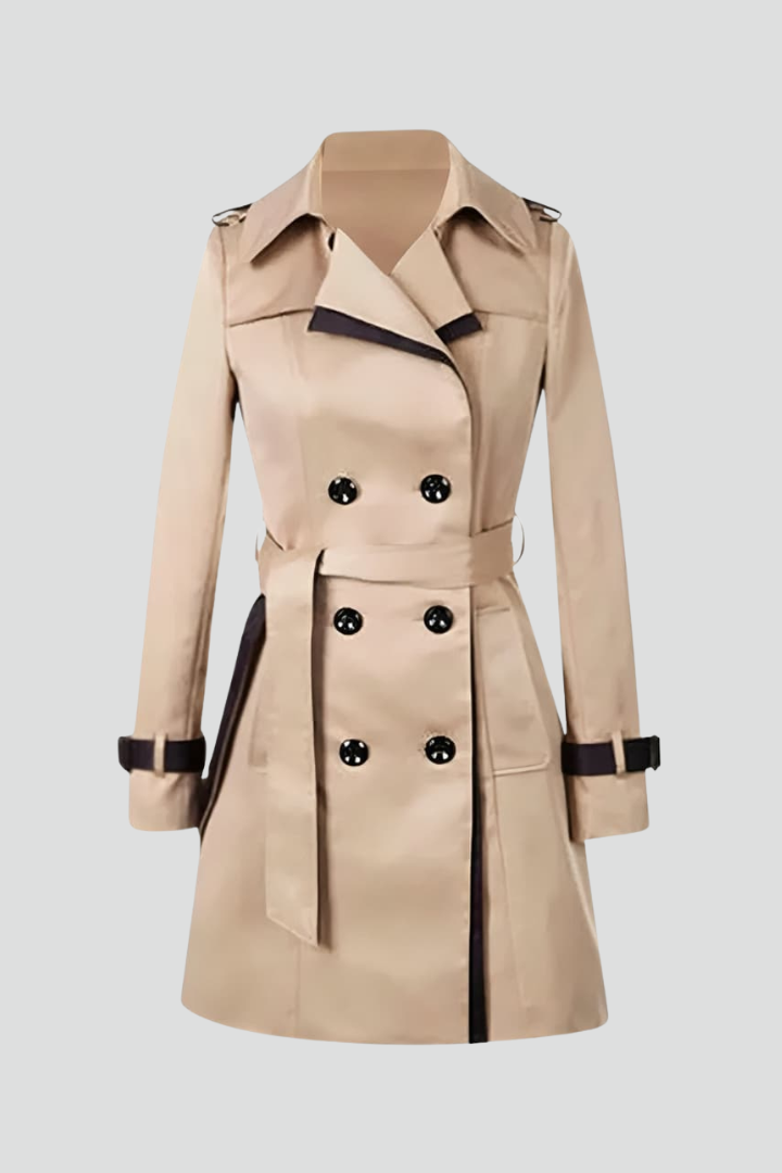 Beiger zweireihiger Trenchcoat mit dunklen Zierkanten, Bindegürtel und Ärmelriemen, freigestellt auf hellgrauem Hintergrund ohne Model. 1