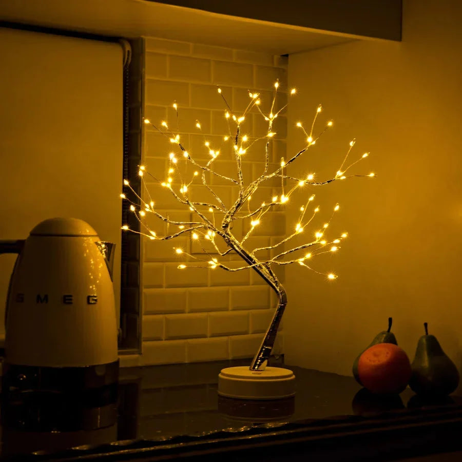 Leuchtender Lichterbaum in der Küche vor gefliester Wand, daneben ein Wasserkocher und Früchte 5