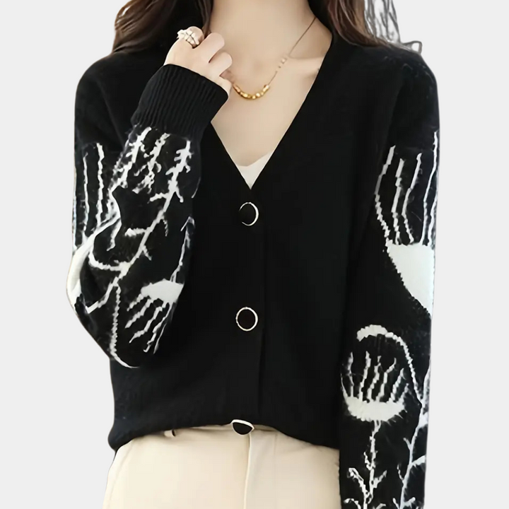 Frau trägt schwarzen Cardigan mit Blumenmuster, V-Ausschnitt, Knöpfen, modisch, elegant.