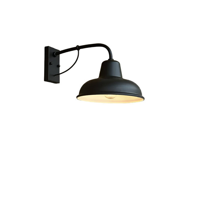 Schwarze Wandlampe mit gebogenem Arm und gewölbtem Schirm, freigestellt vor weißem Hintergrund, im Inneren des Schirms ist eine Glühbirne sichtbar. 1