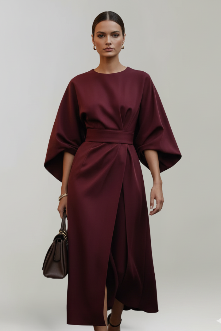 Model in weinrotem Kleid frontal, mit dunkler Handtasche, Taillengürtel und leichtem Beinschlitz im Rock 11
