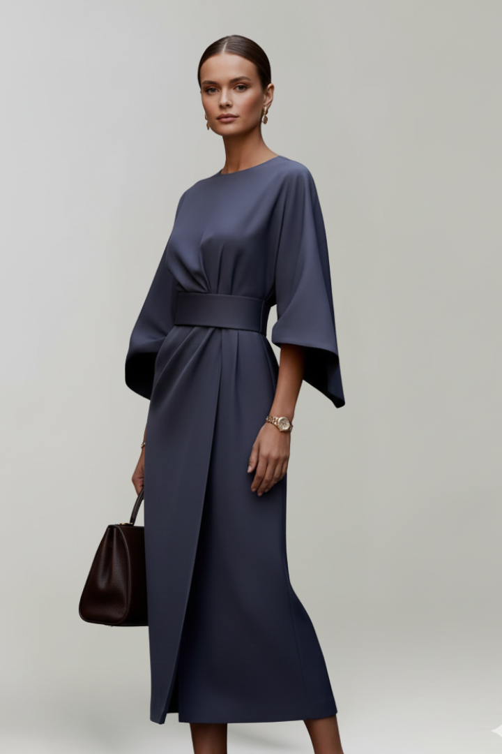 Model in dunkelblauem Kleid in Dreiviertelansicht, die überlappende Wickelpartie des Rocks und der Gürtel sind sichtbar 3