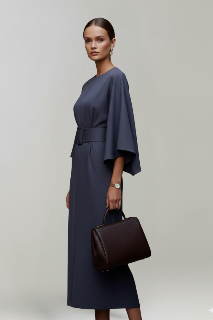 Model in dunkelblauem Kleid im Profil, der Gürtel mit Schnalle und der weite Ärmel sind zu sehen 5
