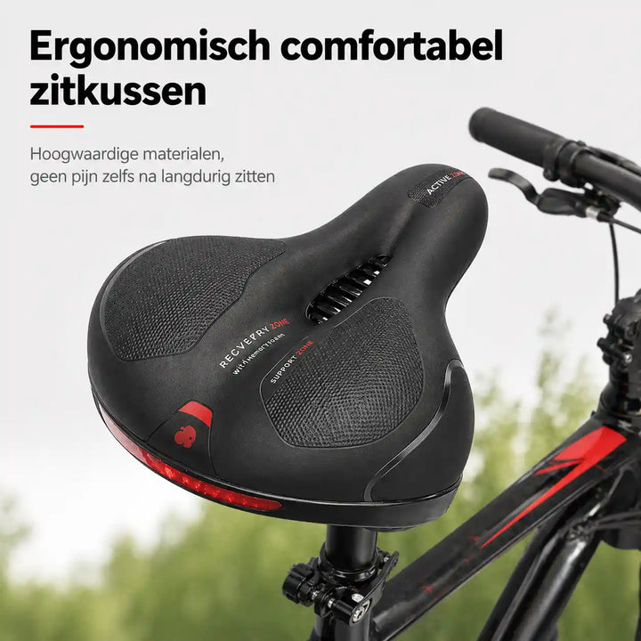 Schwarzer Fahrradsattel mit roten Akzenten und Lüftungsschlitz, auf einem Fahrrad montiert vor unscharfem grünem Hintergrund. 1