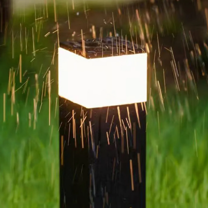 Leuchtender schwarzer Poller im Regen, Wassertropfen spritzen auf Gehäuse und Lichtband, zeigt die Wetterfestigkeit. 9