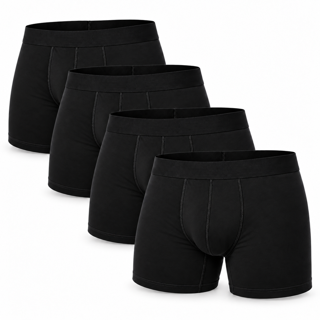 Vier schwarze Boxershorts gestaffelt hintereinander angeordnet, die vorderste zeigt Bund und Nähte von vorn. 12