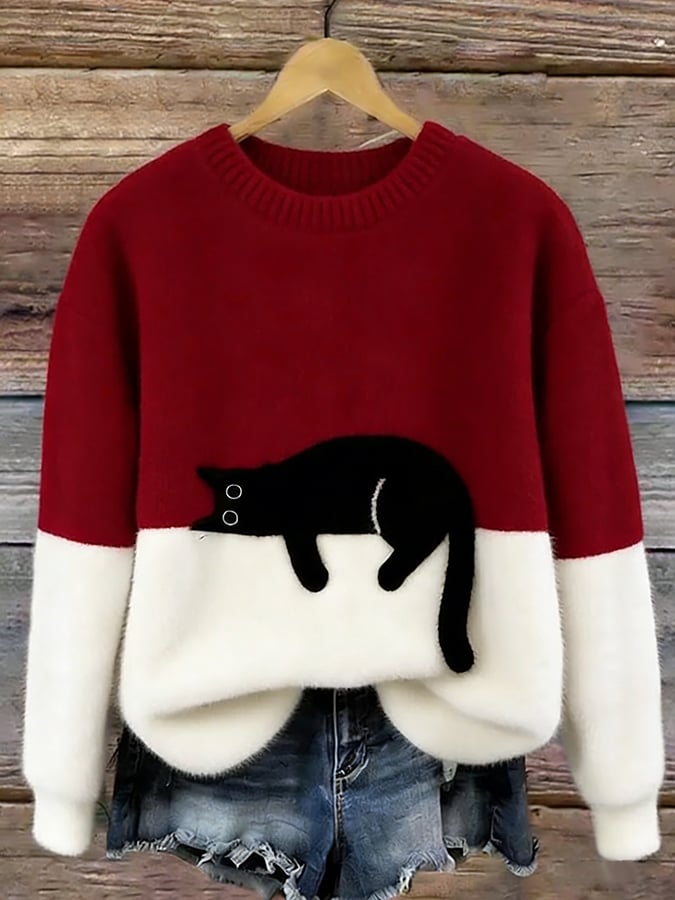 Flauschiger Pullover in Dunkelrot mit weißem Unterteil und aufgenähter schwarzer Katze, an Holzbügel vor Holzwand 6