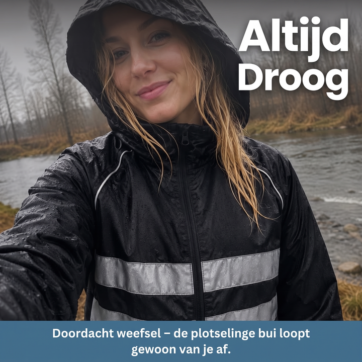 Frau mit Kapuze in schwarzer Jacke mit Reflexstreifen steht im Regen an einem Fluss, Wassertropfen liegen auf dem Stoff. 8