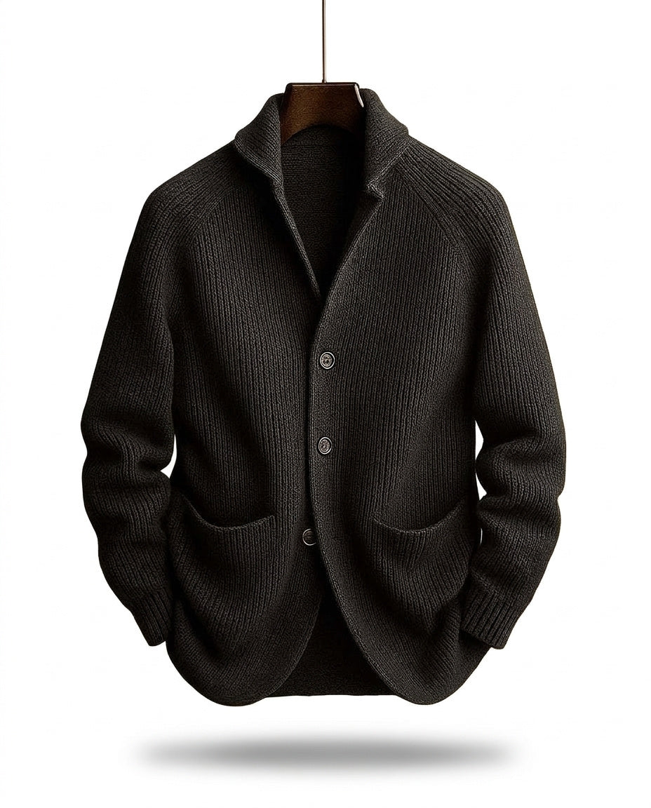 Dunkle, fast schwarze Strickjacke mit Rippstruktur, Schalkragen und Knopfleiste, frei hängend am Bügel mit Schatten darunter. 2