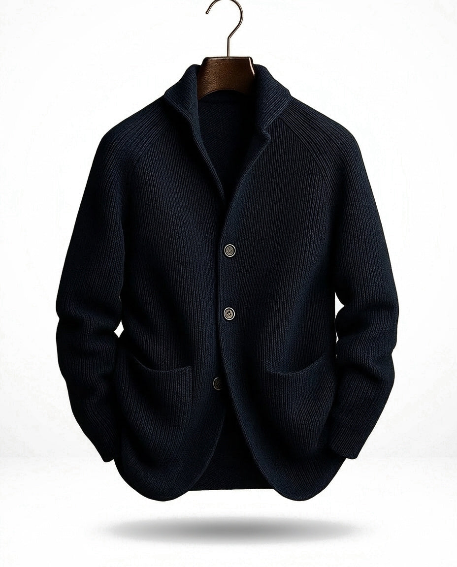 Marineblaue gerippte Strickjacke mit Schalkragen, drei Knöpfen und zwei Taschen, am Haken-Bügel vor hellem Hintergrund. 3