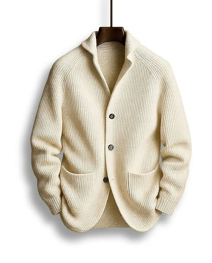 Cremeweiße gerippte Strickjacke mit Schalkragen, drei dunklen Knöpfen und lockeren Taschen, auf dem Bügel von vorn gezeigt. 5