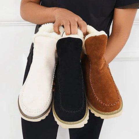 Drei Stiefeletten in Beige, Schwarz und Braun werden nebeneinander gehalten und zeigen das flauschige Futter im Schaftinneren. 7