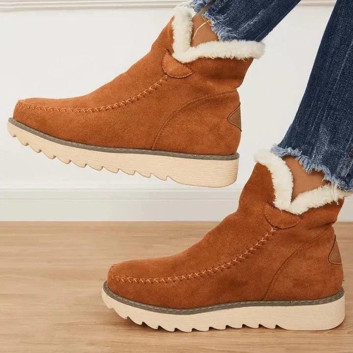 Braune Stiefeletten mit weichem Plüschrand und gewellter heller Sohle, seitlich getragen zu Jeans mit ausgefranstem Saum. 2