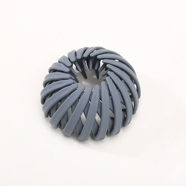 Einzelne matte Klammer in Graublau, von oben und leicht seitlich fotografiert, die Streben verlaufen spiralförmig. 12