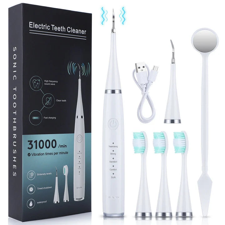 Weißes Set mit Gerät, Verpackungsbox, USB-Ladekabel, gebogenem Scaler-Aufsatz, drei Bürstenköpfen und Mundspiegel nebeneinander angeordnet. 4