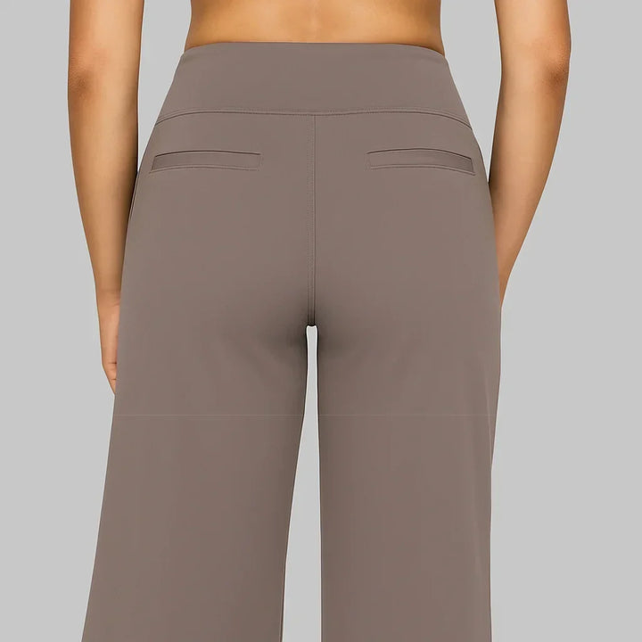 Rückansicht der taupefarbenen Hose mit hohem Bund, zwei schmalen Paspeltaschen und mittiger Naht. 4
