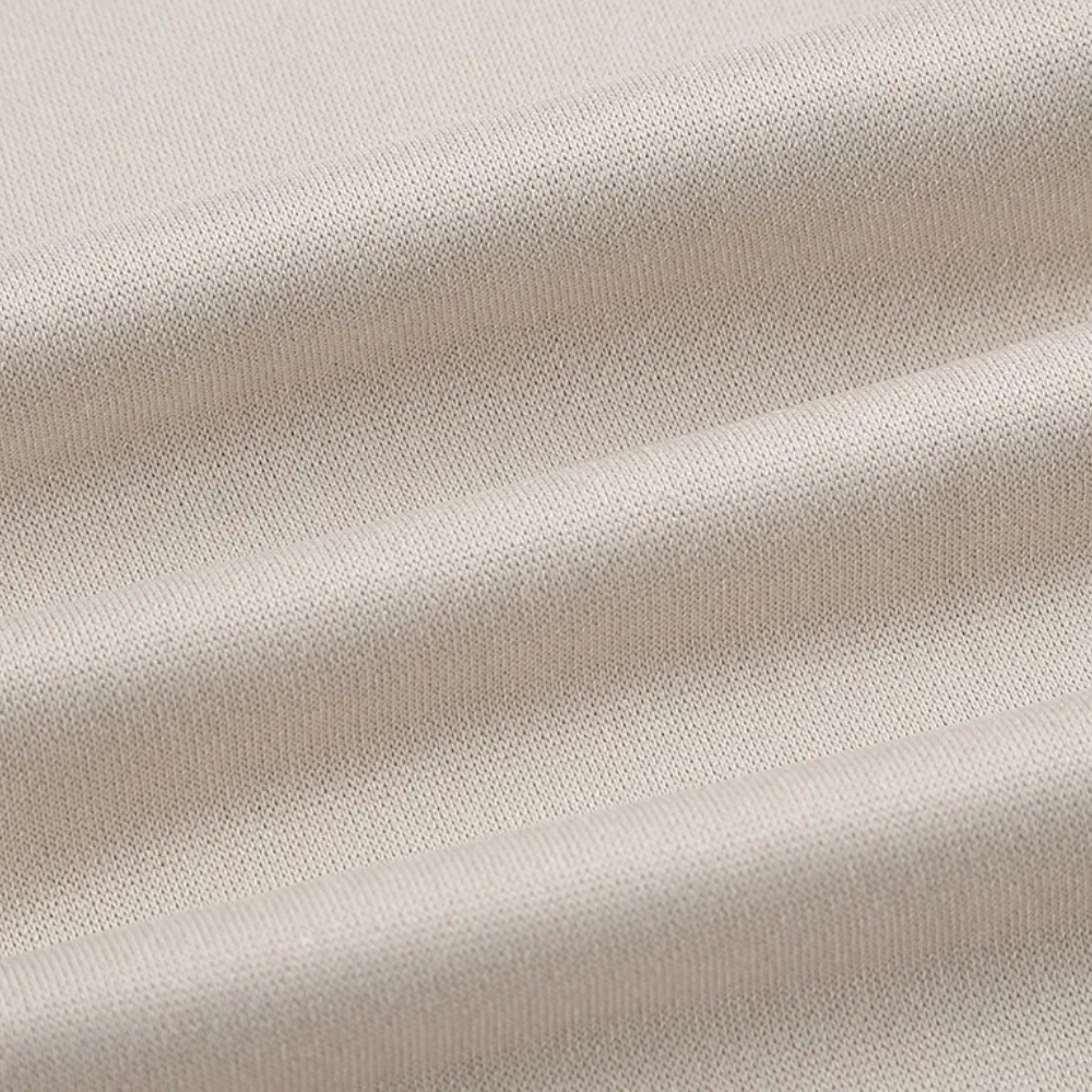 Beiger Baumwollstoff, Nahaufnahme, weiche Textur, ideal für Kleidung und Heimtextilien.