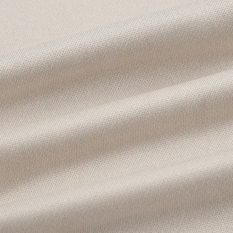 Beiger Baumwollstoff, Nahaufnahme, weiche Textur, ideal für Kleidung und Heimtextilien.
