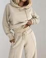 Frau in beigem Hoodie und Jogginghose, Freizeitmode, bequeme Damenbekleidung, Streetwear.