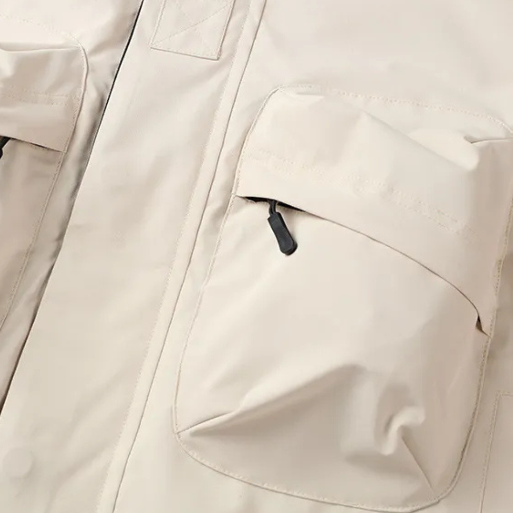 Beige Outdoorjacke mit großen Taschen, wasserdicht, atmungsaktiv, ideal für Wandern und Trekking.