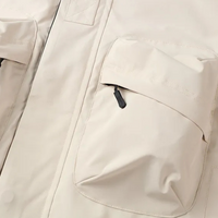 Beige Outdoorjacke mit großen Taschen, wasserdicht, atmungsaktiv, ideal für Wandern und Trekking.