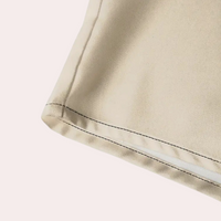 Beiger Stoff mit schwarzer Naht, Detailansicht, hochwertige Textilqualität, Nahaufnahme.