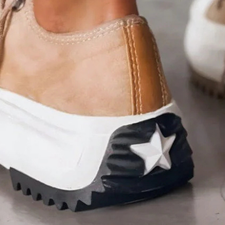 Beiger Sneaker mit weißer Sohle und schwarzem Stern, modische Freizeitschuhe für Damen.