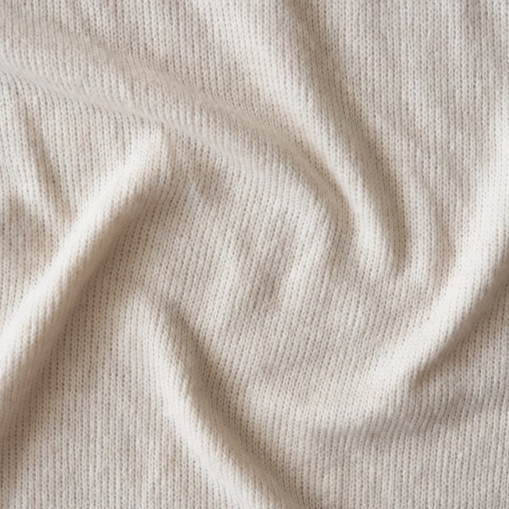 Beigefarbener Strickstoff, weiche Textur, ideal für Pullover und Strickwaren.