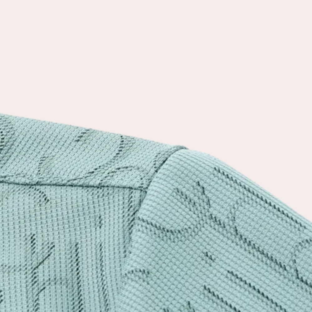 Mintgrüner Strickstoff mit floralem Muster, Nahaufnahme, Textildesign, Mode, Stoffstruktur.