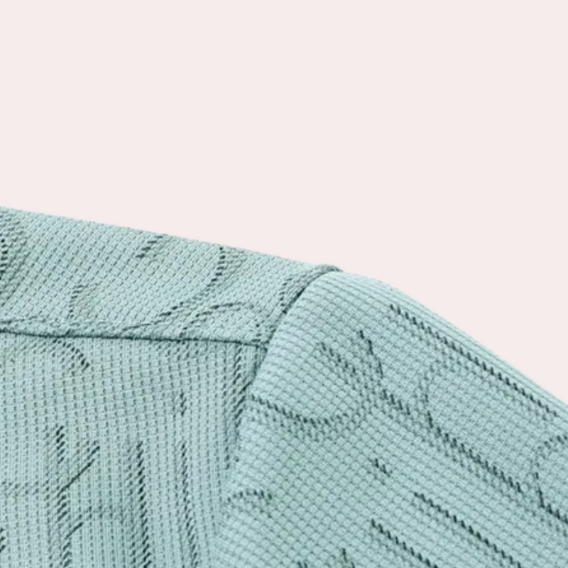 Mintgrüner Strickstoff mit floralem Muster, Nahaufnahme, Textildesign, Mode, Stoffstruktur.