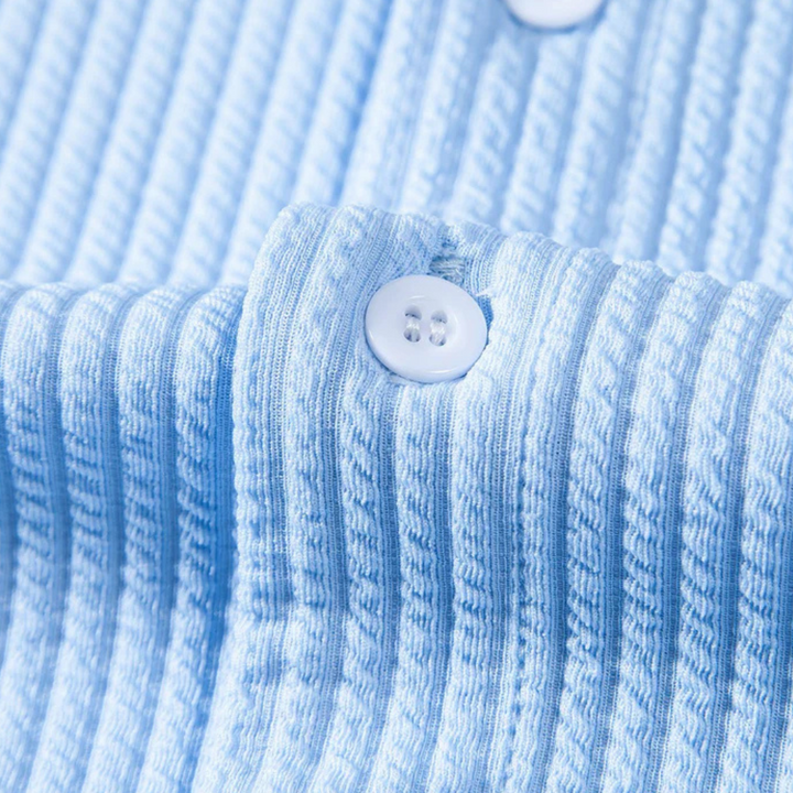 Hellblaues gestreiftes Hemd aus Baumwolle mit Knopfdetail, Nahaufnahme.