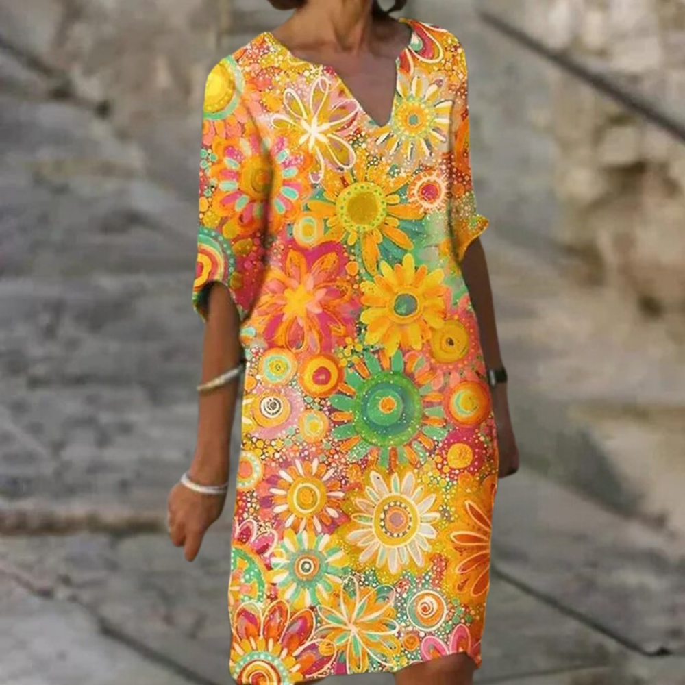 Frau in buntem Blumenkleid, Sommermode, knielang, V-Ausschnitt, lässiger Stil.
