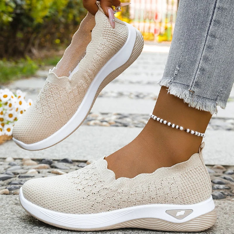 Beige Slip-ons, ein Schuh am Fuß, der andere in der Hand gehalten, Seitenansicht 9