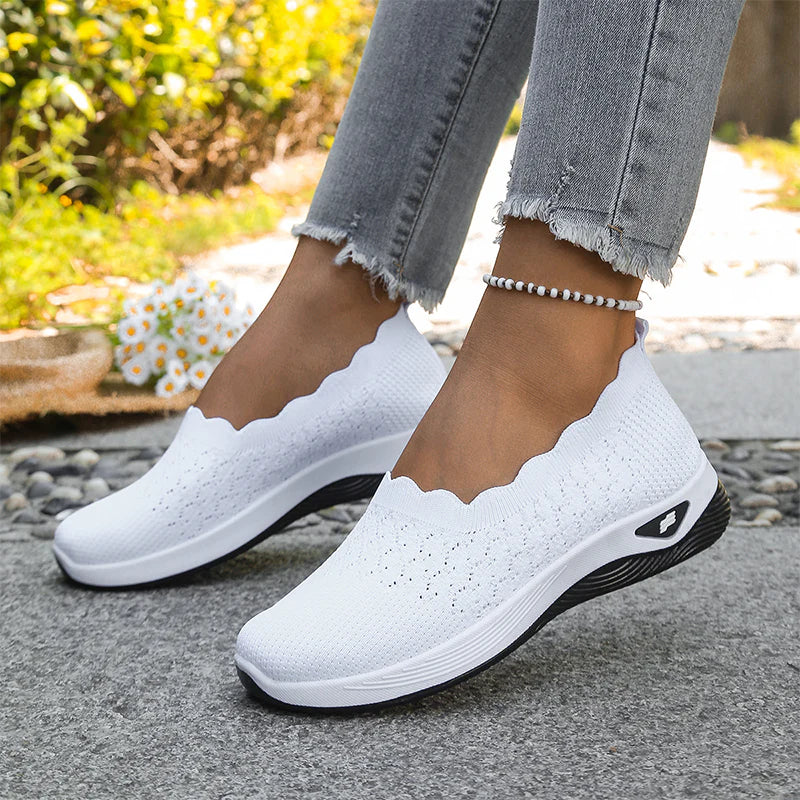 Weiße Strick-Slip-ons mit gewelltem Schaftrand und dicker Sohle, getragen im Freien zu Jeans und Fußkettchen 21