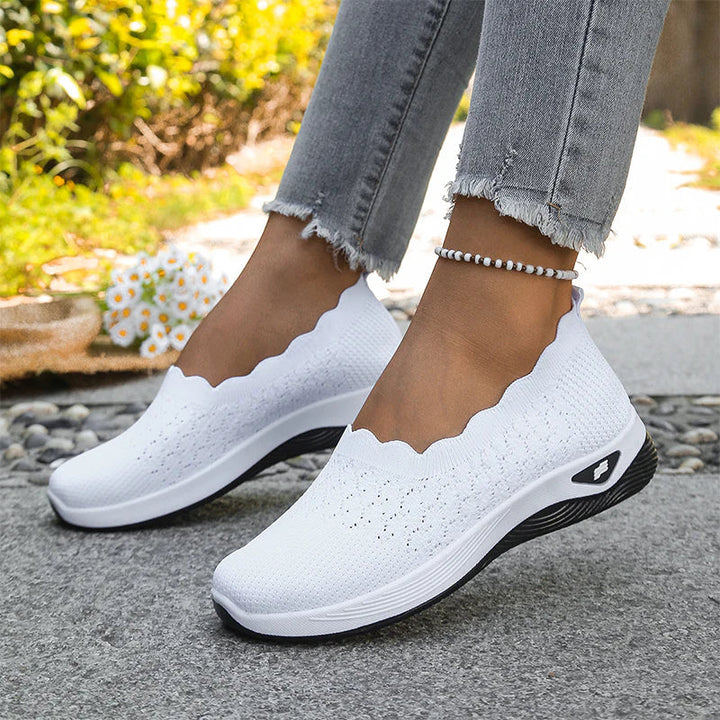 Weiße Strick-Slip-ons mit gewelltem Schaftrand und dicker Sohle, getragen im Freien zu Jeans und Fußkettchen 21