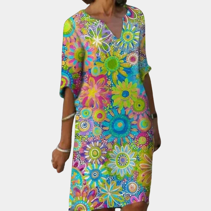 Frau in buntem, geblümtem Sommerkleid, V-Ausschnitt, knielang, lässig, modisch.
