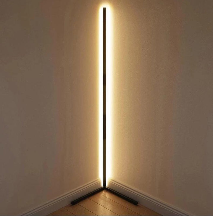 Schwarze Stehlampe steht in einer Raumecke und strahlt warmweißes Licht an beide Wände 12