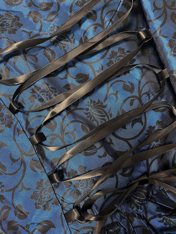 Nahaufnahme der schwarzen Satinband-Schnürung auf dem blauen Stoff mit schwarzem Blumenranken-Muster. 5