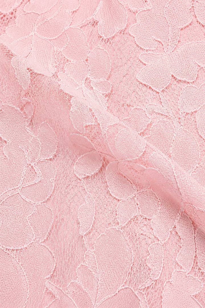 Nahaufnahme des rosa Spitzenstoffs mit Blumenmuster und feinem Netzgrund, leicht gefaltet. 17