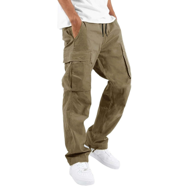 Model trägt die Cargohose in Beige-Khaki mit großen Seitentaschen, Hände in den Taschen, dazu weißes T-Shirt und weiße Sneaker. 3