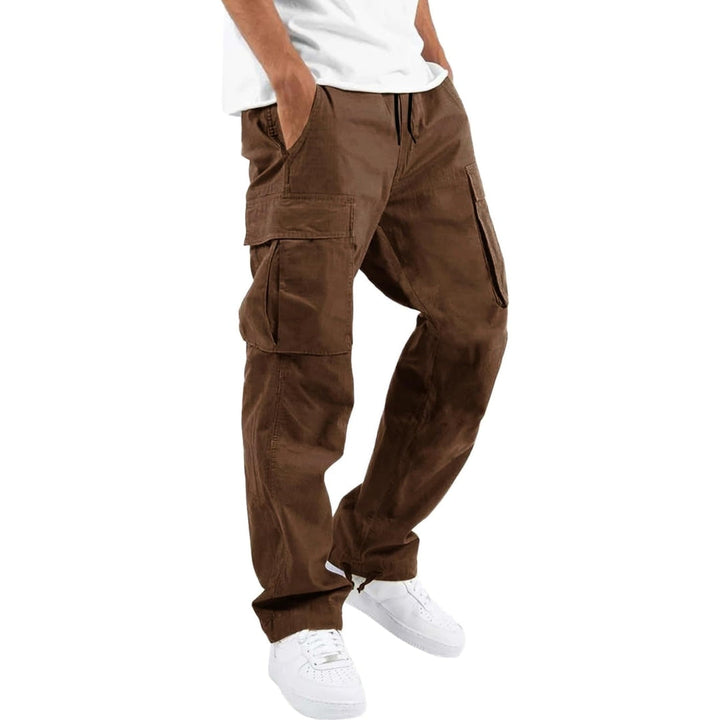 Model trägt die Cargohose in Braun mit Kordelzug am Bund und großen Seitentaschen, dazu weißes T-Shirt und weiße Sneaker. 5